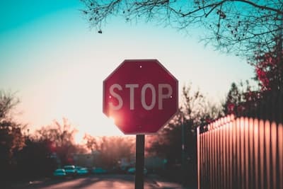 a stop sign on a town and sky backdrop