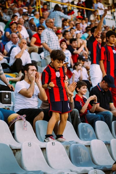 A child celebrating in the stands of a sports field