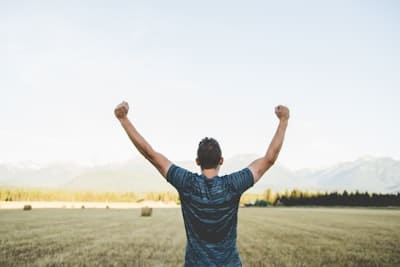 a man in a field cheering