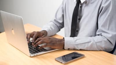 man typing on laptop