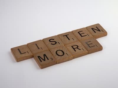 scrabble tiles spelling out listen more