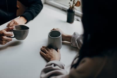 two people conversing over coffee