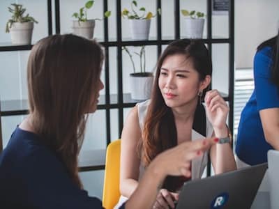 two women holding a conversation at an office